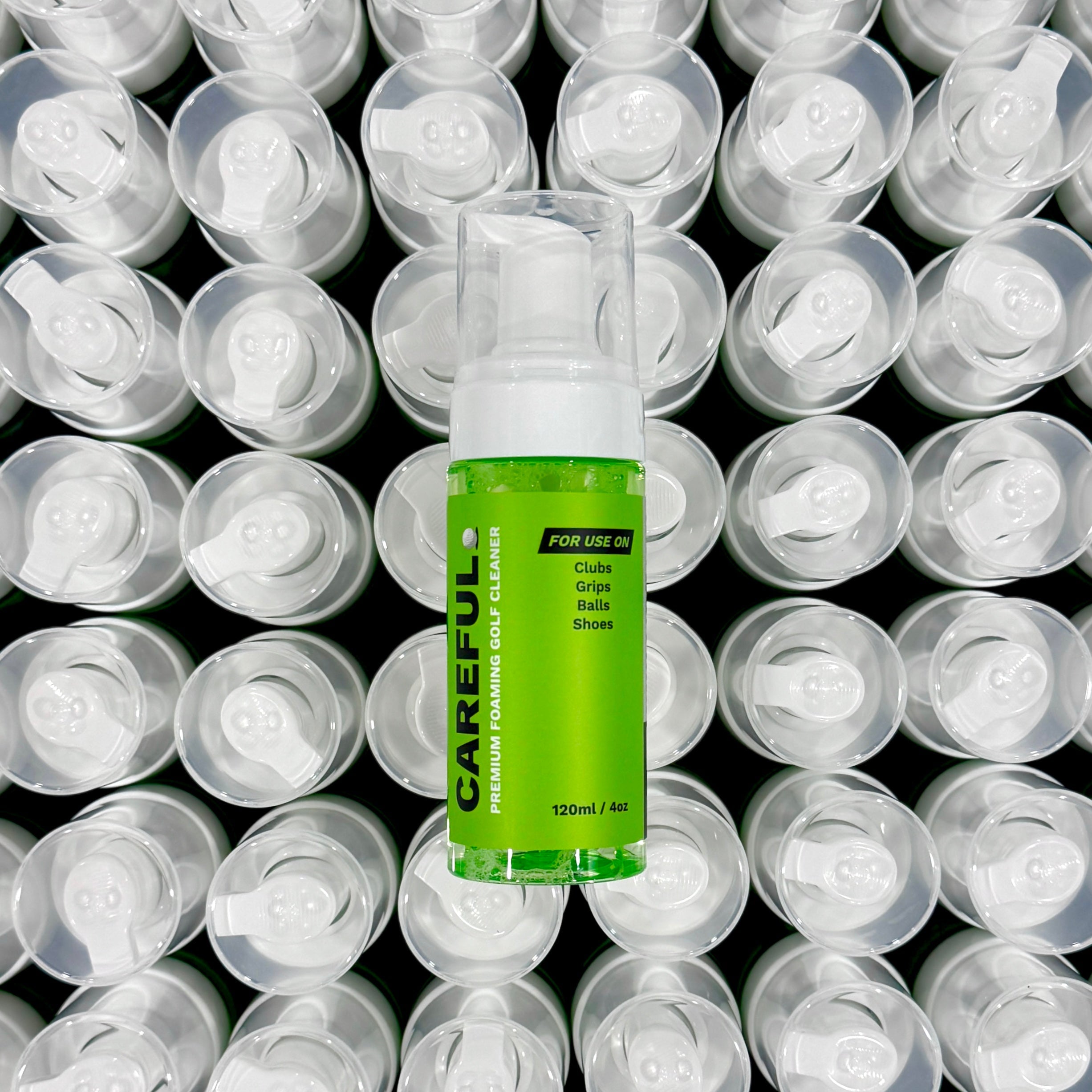 image of careful golf 4-in-1 premium foaming golf cleaner laying on top of a other bottles with the top caps as the background. 
